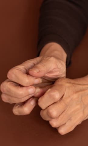 Someone's hands, picking nervously at their nails
