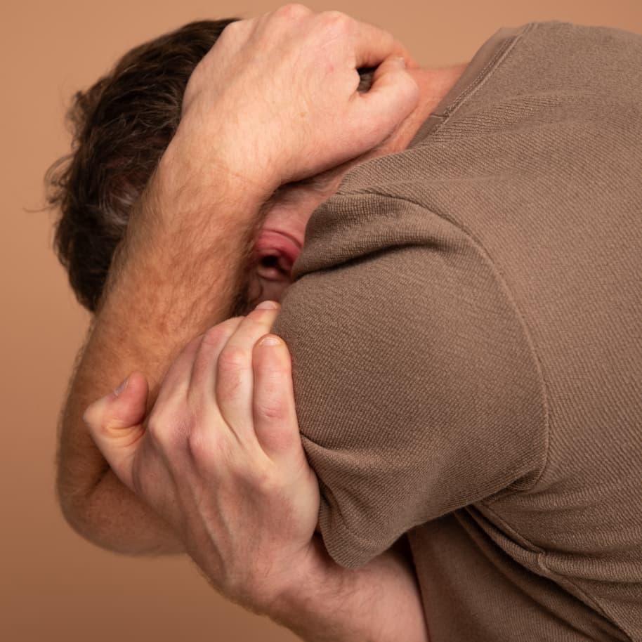Man wrapping his head in his hands.